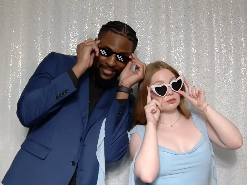 Wedding guest posing with playful photo booth props